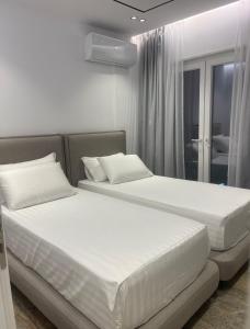 dos camas sentadas una al lado de la otra en un dormitorio en Olivea Apartments, en Velipojë