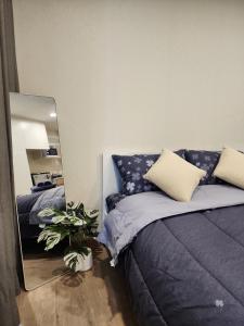 a bedroom with a blue bed and a mirror at East Ville-45 in Ban Hua Khao Sammuk