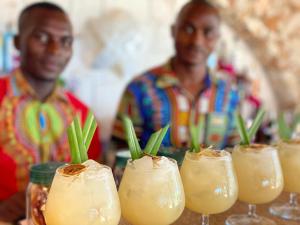 dos hombres parados frente a una mesa con bebidas en Jaz Amaluna Hotel, en Uroa