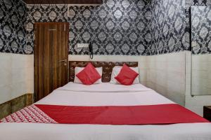 a bed with red pillows in a room at OYO Flagship Hotel Sapna Residency in Mumbai