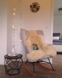 a furry chair with a table in a room at Harksen Hüs in Klixbüll