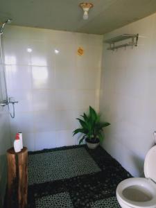 uma casa de banho com WC e uma planta em Coconut Homestay Tetebatu em Tetebatu