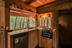 a kitchen with a stove and a window in a cabin at Casa de barro in Santa Ana