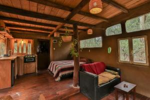 a living room with a couch and a bed in a house at Casa de barro in Santa Ana