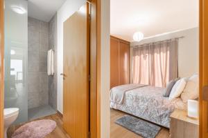 ein Schlafzimmer mit einem Bett und ein Badezimmer mit Dusche in der Unterkunft Villa Angela- Madeira Inn Group in Calheta + 49 Fotos