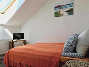 1 dormitorio con 1 cama, TV y silla en FLORIAN - tuż przy plaży, en Mielno