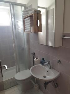 a bathroom with a sink and a toilet and a shower at Soba brez balkona in Stara Novalja