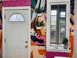 a hallway with a white door and a colorful wall at Ultimate Pet-friendly Studio #1, Patio in Halifax