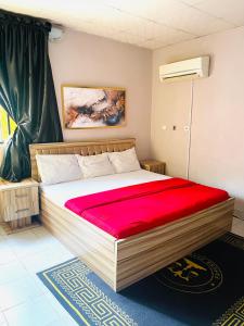 sypialnia z dużym łóżkiem i czerwonym kocem w obiekcie OD-V!CK'S BUDGET ROOMS, 24HR POWER, SECURITY, DSTV w mieście Abudża