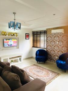 a living room with a couch and a tv at OD-V!CK'S BUDGET ROOMS, 24HR POWER, SECURITY, DSTV in Abuja