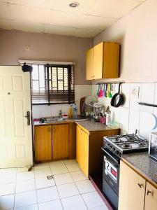 a kitchen with wooden cabinets and a stove top oven at OD-V!CK'S BUDGET ROOMS, 24HR POWER, SECURITY, DSTV in Abuja