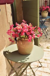 una olla de flores rosas sentada en una mesa en Embarben Maison d'hôtes, en Saint-Chamas