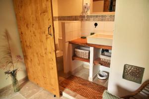 ein Badezimmer mit einem Waschbecken und einer Holztür in der Unterkunft Embarben Maison d'hôtes in Saint-Chamas