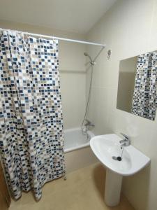 a bathroom with a sink and a shower curtain at Easy Rent Management 292 in Roldán