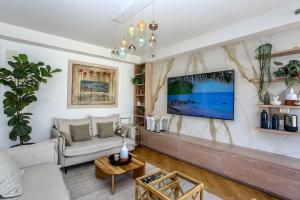 un soggiorno con divano e TV a parete di Ultra Luxury 3BR Beach Apartment a Tel Aviv