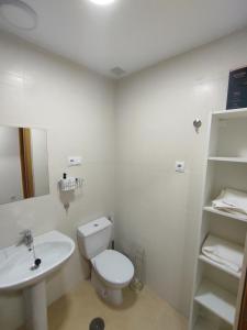 Baño blanco con aseo y lavamanos en Easy Rent Management 292 en Roldán