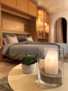 a candle sitting on a table next to a bedroom at Allgäu Neschd in Oberreute