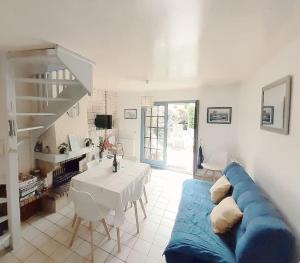 un salon avec un canapé bleu et une table dans l'établissement Charment Cottage de 45 m2 Rénové et moderne, à Villers-sur-Mer
