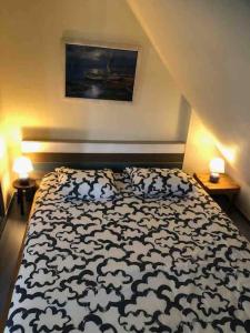 1 dormitorio con 1 cama en blanco y negro con 2 lámparas en Charment Cottage de 45 m2 Rénové et moderne, en Villers-sur-Mer