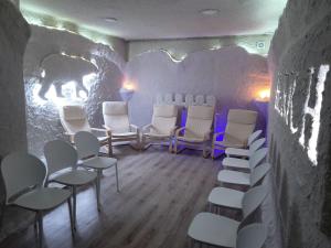 um quarto com cadeiras brancas e uma parede com um mural de urso em SPA Resort HeRICH em Bukovel