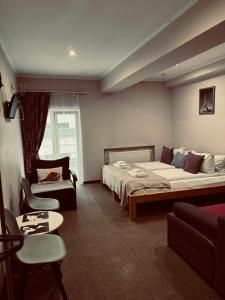 sypialnia z 2 łóżkami, kanapą i krzesłem w obiekcie Apart Hotel Avinos w Lwowie