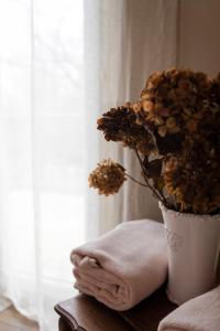 a vase with flowers on a table next to a window at Le Jardin-chambres d'hôtes en Baie in Cahon +69 photos