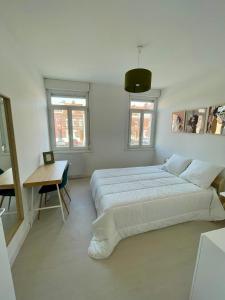 1 dormitorio con 2 camas, escritorio y 2 ventanas en Maison de ville Valenciennes proche Lille, Villeneuve-d'Ascq - 6 chambres avec 6 lits doubles, en Anzin