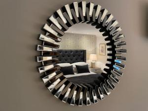 a mirror on a wall with a bed in a room at Beautiful Baslow Bolthole (close to Chatsworth) in Baslow