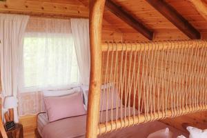 una camera da letto con letto sospeso in una cabina di The Treehouse of The Dragon a Protópappas