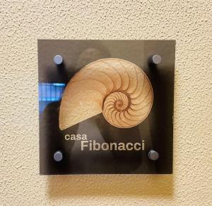 un cartello con un guscio su un muro di Casa Fibonacci a Pisa