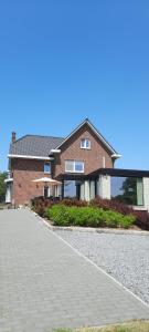 a large brick house with a cobblestone driveway at B&B Gellick in Lanaken