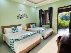 duas camas num quarto com paredes verdes em Hy Vien Boutique and Garden em Hue