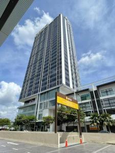 um edifício alto com um sinal em frente em REVO Aurora @ Pavilion Bukit Jalil Kuala Lumpur em Kuala Lumpur