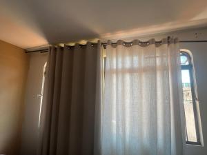 a curtain in a room with a window at Local privilegiado no Bueno com Ar Tv e banheiro privativo! in Goiânia