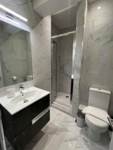 a bathroom with a toilet and a sink and a shower at The Hurdwick in London