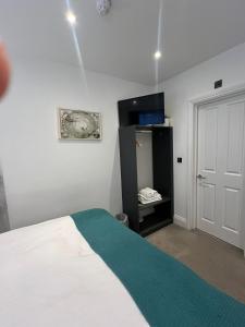 1 dormitorio con 1 cama, armario y puerta en The Hurdwick, en Londres