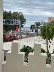 einen weißen Zaun mit Blick auf den Strand in der Unterkunft Corniche Palace Hotel in Ajman 