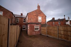 a brick house with a fence in front of it at Heart of the City beautiful 3 bed 2 bath sleep 6 in Lincoln
