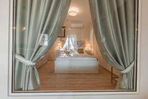 希羅皮加多的住宿－Paralio Astros Beachfront Suites，一间卧室配有床和带窗帘的窗户