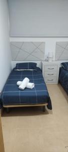 a bedroom with a blue bed with two white towels at Easy Rent Management 292 in Roldán