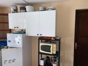 uma cozinha com armários brancos e um micro-ondas em Domaine de Kanelle em Rivière-Pilote