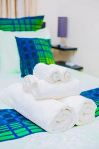 a pile of towels sitting on top of a bed at Z Apartment (4bedroom) in Lusaka