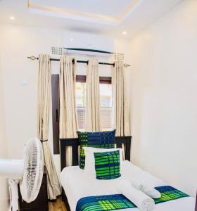 a bedroom with a bed with green and white pillows at Z Apartment (4bedroom) in Lusaka
