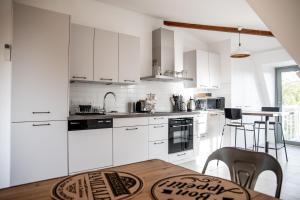 uma cozinha com armários brancos e uma mesa de madeira em Chestnut House Appartment em Le Mée-sur-Seine