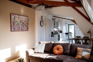 ein Wohnzimmer mit einem Sofa und einer Küche in der Unterkunft Chestnut House Appartment in Le Mée-sur-Seine