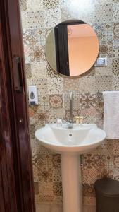 La salle de bains est pourvue d'un lavabo et d'un miroir. dans l'établissement Sami Holiday Inn - pyramids view Rooftop, au Caire