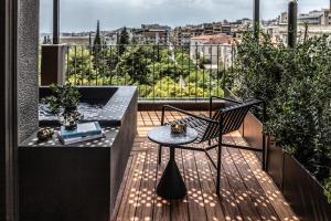 Un balcón con una mesa y una silla en una terraza. en The Modernist Athens, en Atenas