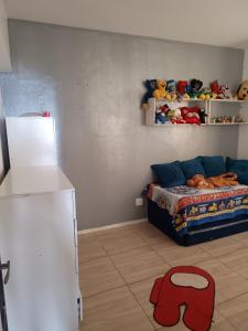 a room with a bed and shelves with stuffed animals at A casa azul em frente a praia ambiente familiar in Guarujá