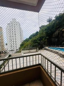a balcony with a view of a swimming pool at A casa azul em frente a praia ambiente familiar in Guarujá