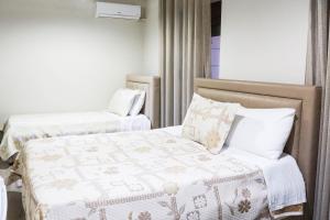 Dos camas en una habitación de hotel con una manta. en Vila Leo Lux en Korçë